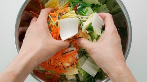 Tossing Napa cabbage, carrots, scallions and ginger together with salt to make Asazuke pickles.