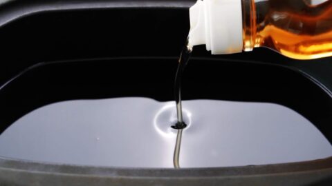 Pouring sesame oil into a pot for deep frying the tofu.