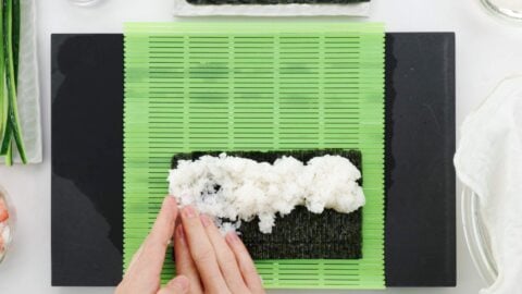 Spreading rice into nori for California roll.