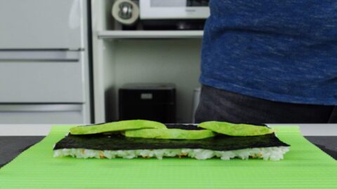 Placing sliced avocado on nori.