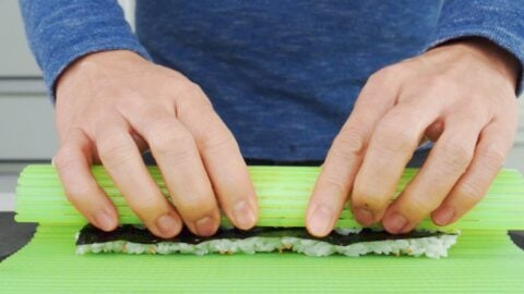 Forming the roll with a sushi mat.