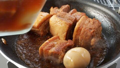 Glazing kakuni with reduced braising liquid.