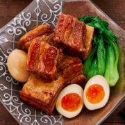 Melt-in-your-mouth tender, pork belly kakuni cubes bathe in a rich, umami-laden sauce, paired with vibrant bok choy, golden soft-boiled eggs, and a steaming bowl of rice for the ultimate comfort meal.