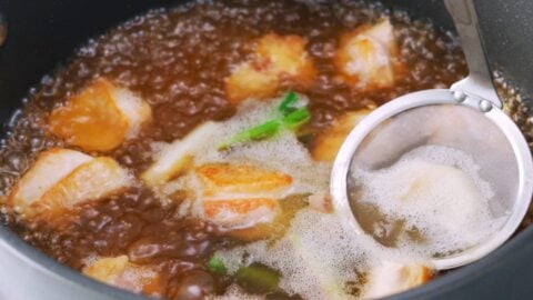 Skimming chicken broth for Japanese udon noodle soup.
