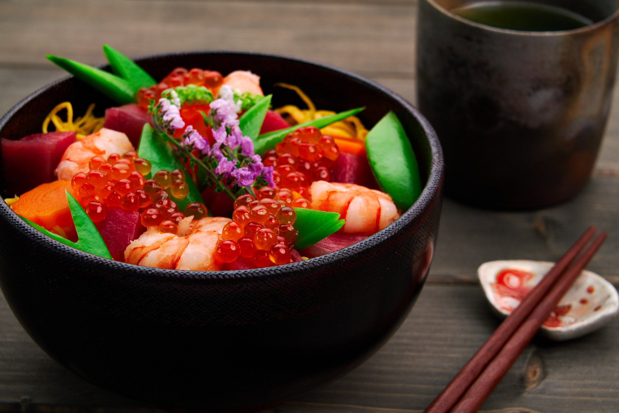 Kaisen Chirashi Sushi with seafood, and veggies scattered over a bowl of sushi rice.