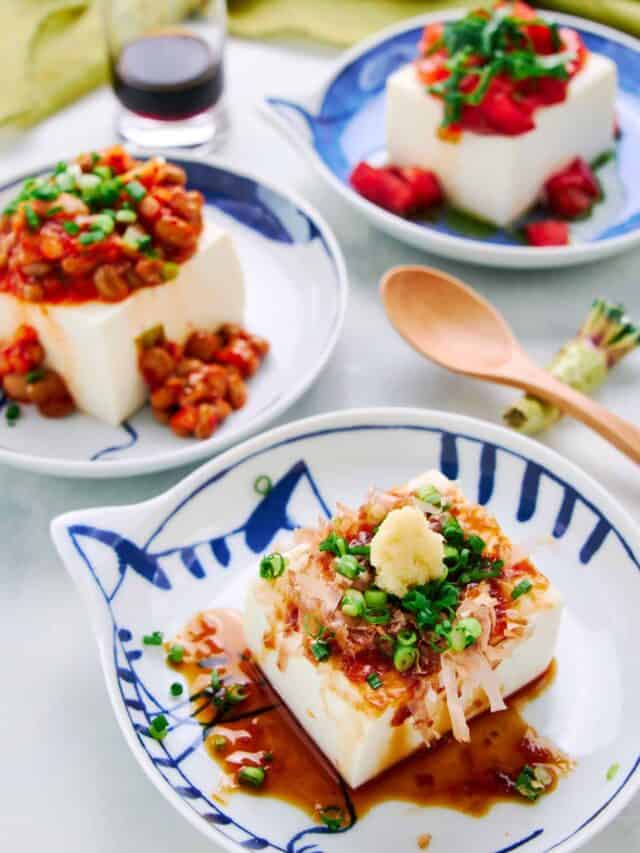 Hiyayakko is a Japanese cold tofu dish topped with katsuobushi, scallions, ginger, and soy sauce. In the background, two modern variations of this tofu salad include Kimchi Natto and Caprese Salad.