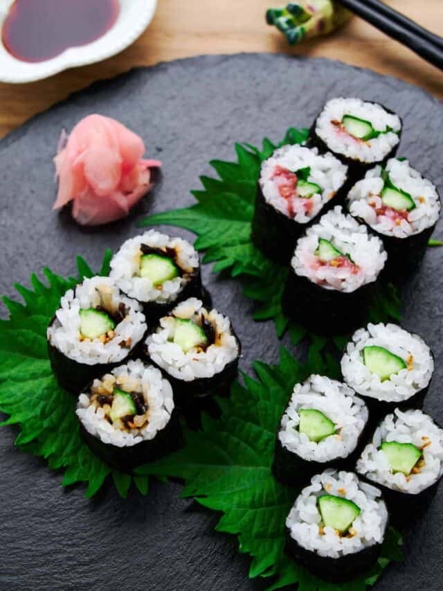 3 variations of Kappa Maki sushi rolls or cucumber sushi on a black plate with crispy cucumber and seasonings rolled with sweet and tangy sushi rice, and crisp nori.