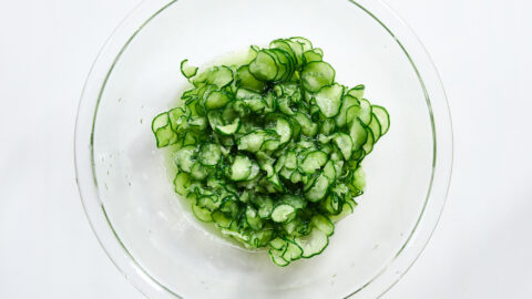 Salted cucumber slices after being massaged release their water, a key step for achieving that signature crunch.
