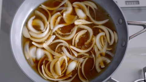 Simmering onions together with a dashi broth to make gyudon.