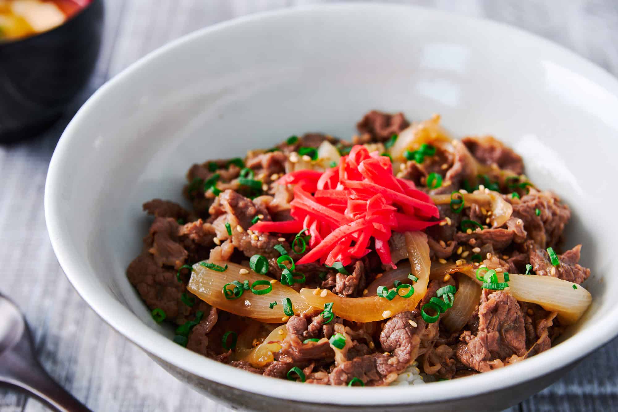 A lunchtime staple in Japan, this Gyudon or Japanese beef bowl includes thinly sliced beef and onions in a savory broth served over a bowl of hot rice.