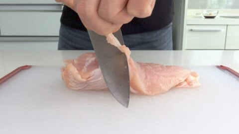 Trimming gristle and fat from chicken breast to make teriyaki.