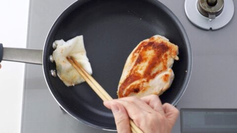 Wiping out excess oil with paper towel before adding teriyaki sauce.