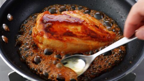 Glazing chicken with honey teriyaki sauce.