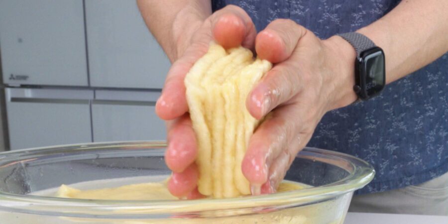 Squeezing excess water and oil from fried tofu wrappers.