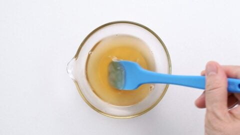Sushi seasoning being mixed in a glass bowl.