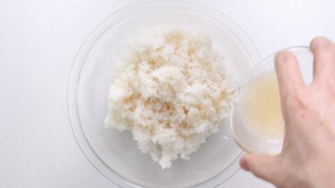 Pouring sushi vinegar over rice.