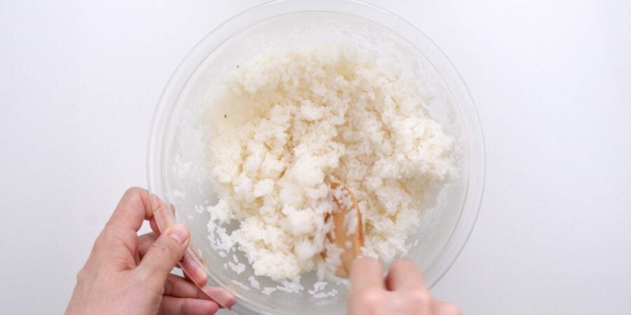Mixing sushi seasoning into rice.