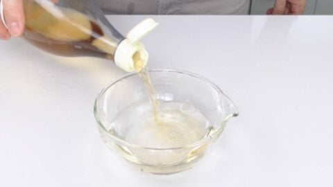 Adding rice vinegar to a bowl of water.
