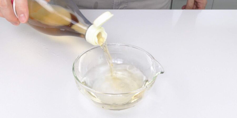 Adding rice vinegar to a bowl of water.