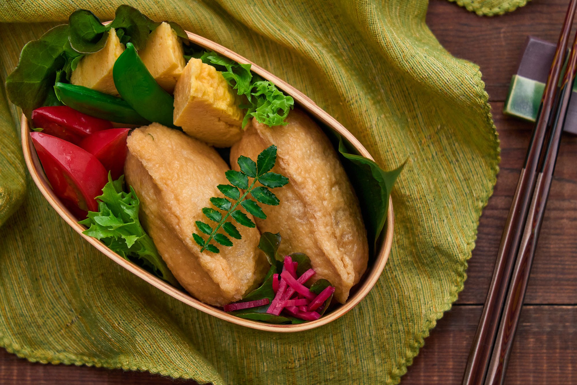 A vibrant bento featuring inari sushi nestled among colorful vegetables—perfectly balanced with sweet tofu, tangy rice, and crisp seasonal sides.
