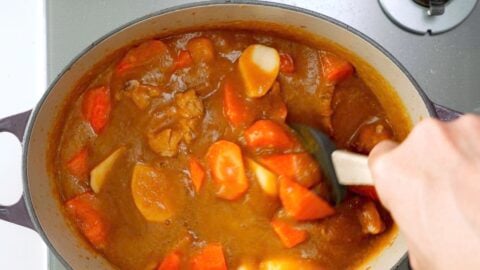 Stirring potatoes, carrots and chicken into the Japanese curry sauce.