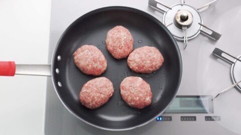 Hamburg steak patties in a frying pan.