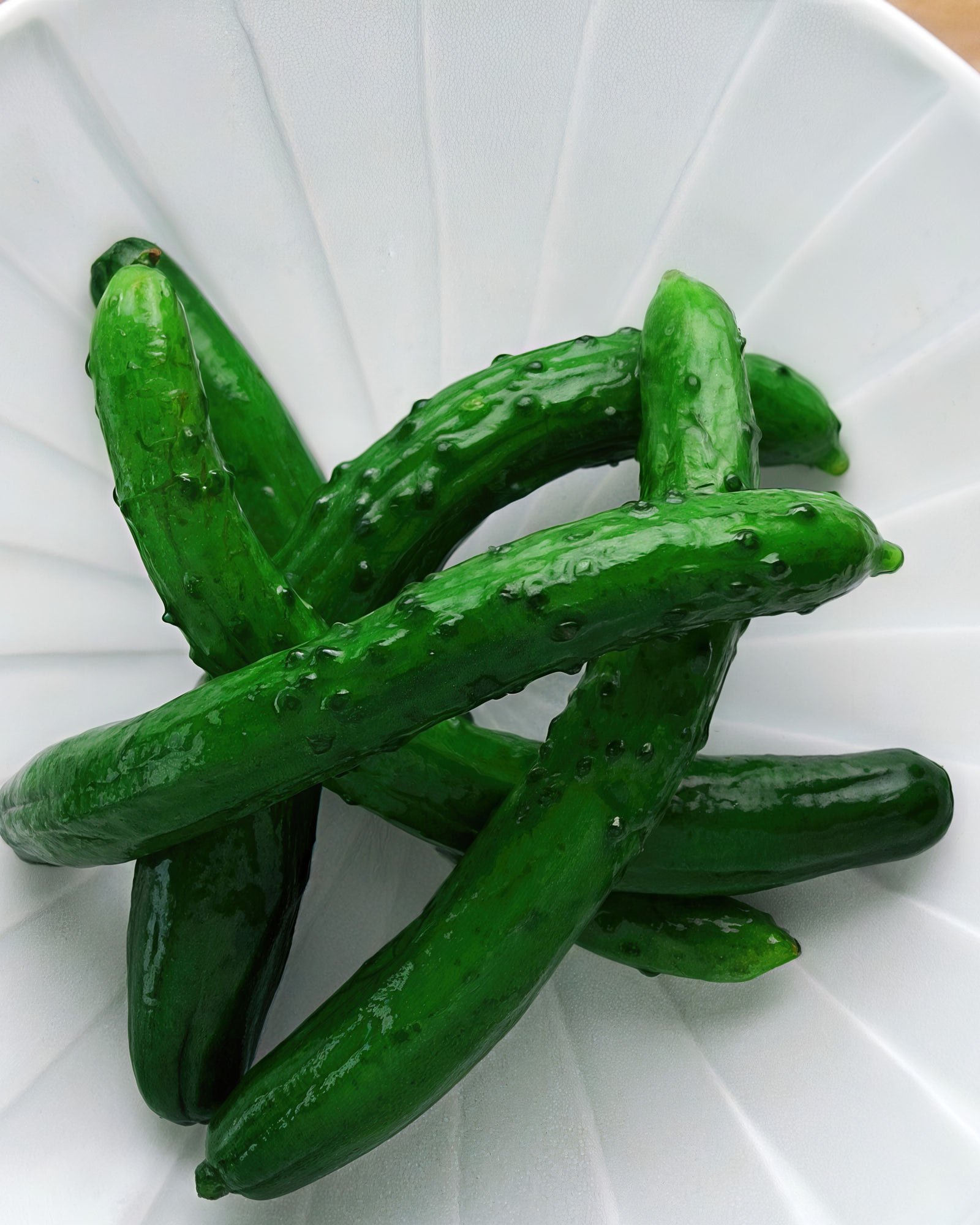 Whole Japanese pickled cucumbers glisten on a plate—crisp, refreshing, and bursting with savory umami from a simple salt brine.