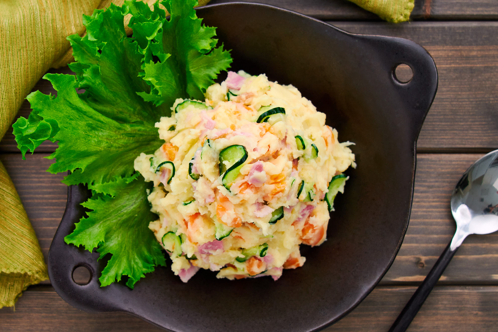 Overhead view of a plate of Japanese Potato salad garnished with lettuce.