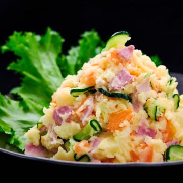 Mound of Japanese potato salad with ham, cucumbers, carrots and onions.