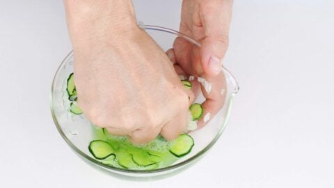 Squeezing excess water from salted cucumbers and onions.