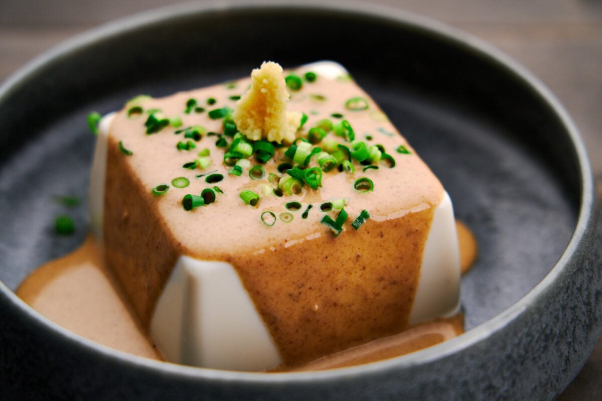Hiyayakko (Chilled Tofu) served with Goma Dare (sesame sauce) topped with scallions and grated ginger.