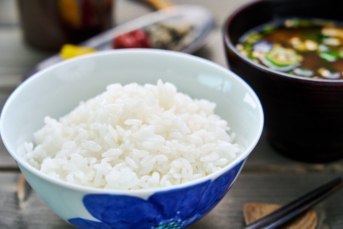 A bowl of perfect Japanese short-grain rice along with traditional Japanese breakfast foods such as miso soup and pickles.