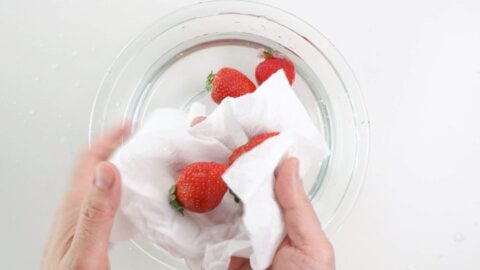 Drying strawberries with paper towels.