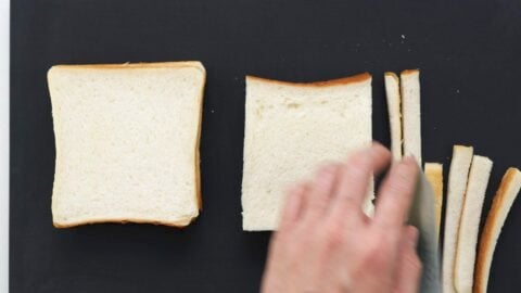 Cutting crusts off of sandwich bread.