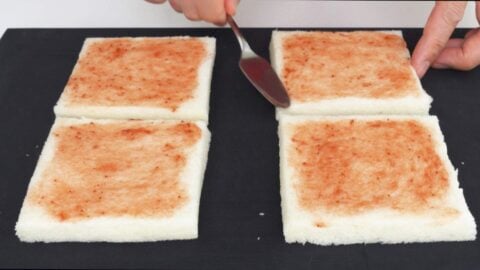 Spreading strawberry jam on Japanese sandwich bread.