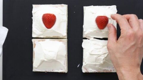 Placing strawberries on the cream.