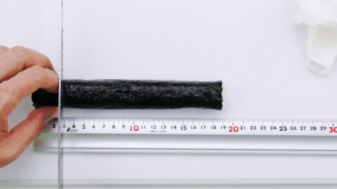 Using a ruler to cut sushi rolls.
