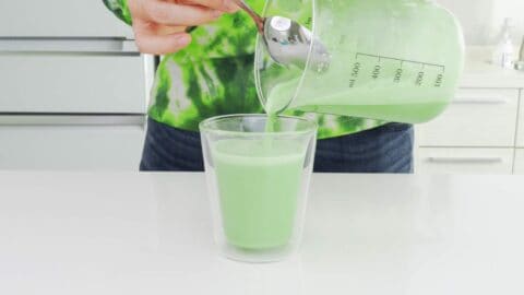 Serving matcha latte in an insulated glass mug.
