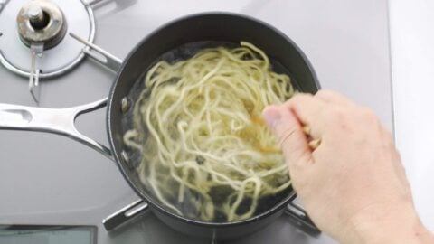 Boiling thick ramen noodles.