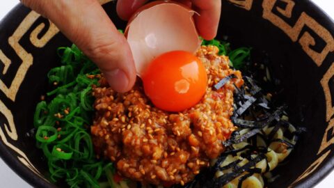 Topping mazesoba with a raw egg yolk.