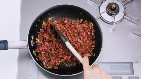 Crumbling ground beef to taco rice.