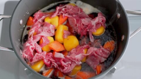 Layering in the potatoes, carrots, beef, onions, tomatoes and shirataki.