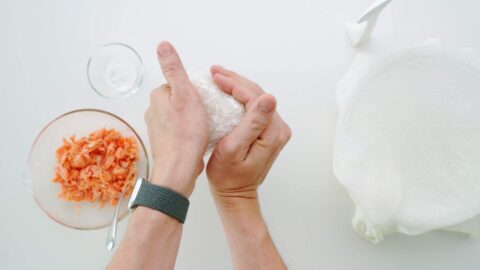 Shaping salmon onigiri with hands.