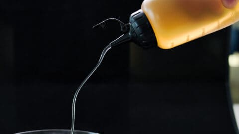 Stream of authentic sushi vinegar pouring out of a squeeze bottle.