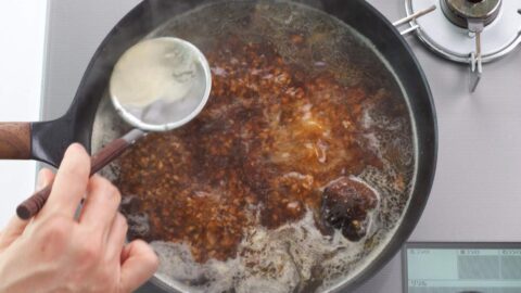 Skimming shoyu ramen broth.