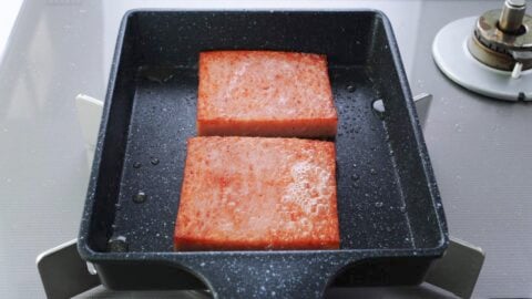 Browned onigiri slabs in a frying pan.