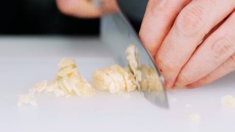 Chopping smashed garlic.