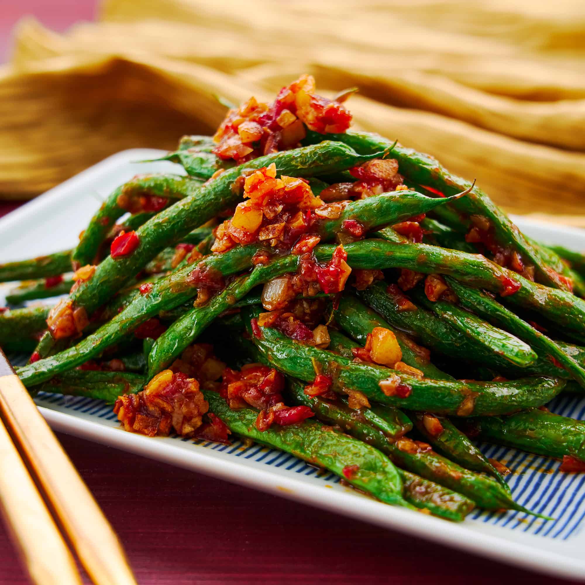 Mound of green beans stir fried with garlic and chili paste. An easy vegan Chiense stir-fry.