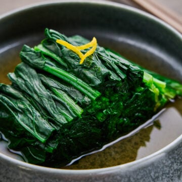 A bowl of Spinach Ohitashi, a Japanese salad made by blanching spinach and infusing it with an umami-rich dashi marinade.