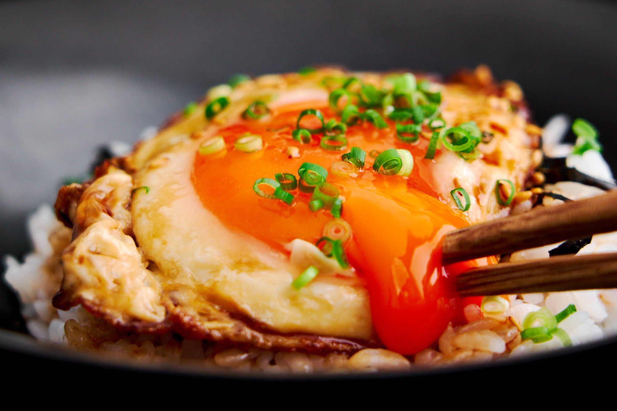 Breaking the molten yolk of a teriyaki egg over rice.